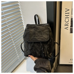 Détail du sac à dos noir style rétro avec texture plissée et fermeture par cordon serrage