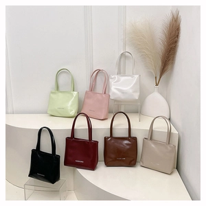 Petits sacs cabas minimalistes en cuir verni brillant présentés en sept couleurs