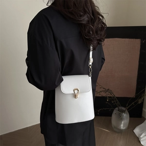 Minimalist white leather crossbody bucket bag with horseshoe gold metal buckle detail
