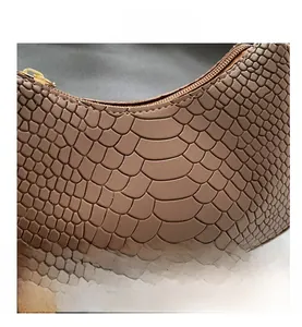 Close-up of brown crocodile texture leather and premium gold metal zipper on shoulder bag