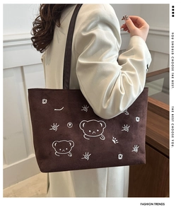 Detail of bear embroidery on brown suede tote bag with leather strap for women