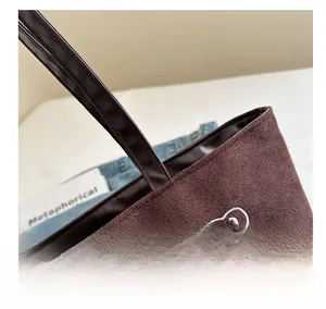 Close-up of brown faux suede tote bag featuring detailed bear embroidery and fine stitching