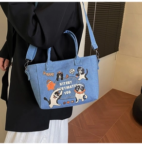 Detailed view of casual blue denim tote bag with cute cat illustrations and wide strap