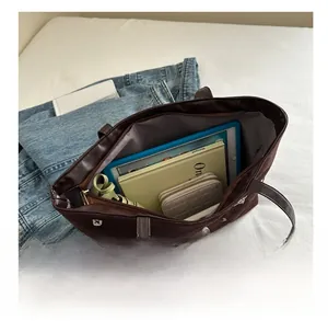 Spacious interior of dark brown tote bag showing capacity for tablets and books