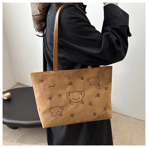 Detail of vintage brown suede tote bag featuring cute cartoon bear print and slim strap