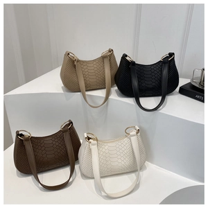 Close-up of four minimalist snakeskin texture shoulder bags with gold ring accents