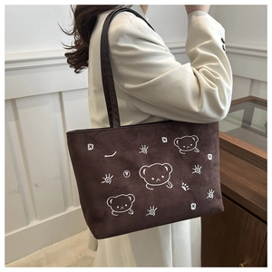 Brown faux suede tote bag with cute bear prints shown on shoulder for daily casual use