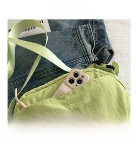 Detail of light green nylon crossbody bag with side pocket for smartphone storage