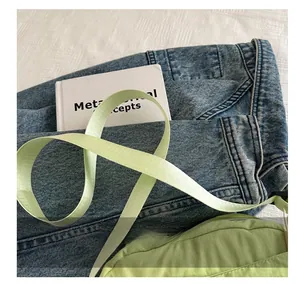Close-up of light green nylon crossbody bag strap with durable woven texture details
