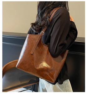 Detail of dark brown oil wax leather tote bag with adjustable silver buckle strap