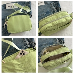 Detail view of light green nylon crossbody bag with waterproof texture and multi-layer pockets
