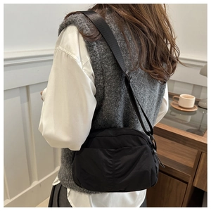 Side view of black nylon crescent crossbody bag with wide adjustable shoulder strap