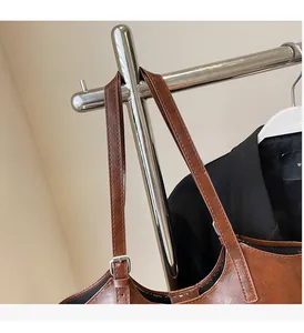 Detail of adjustable brown leather handle with neat stitching on a vintage tote bag