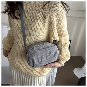 Gray lightweight nylon crossbody bag showing adjustable strap and casual draped design