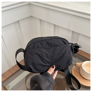 Close-up of durable black nylon crossbody bag with adjustable strap and textured fabric