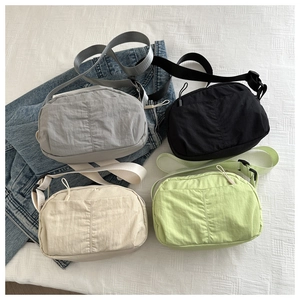 Detail view of multi-color nylon crossbody bags with adjustable straps and zipper texture
