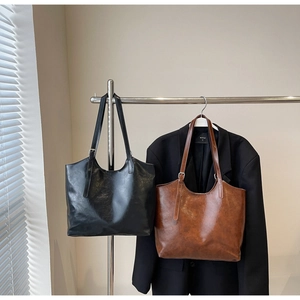 Detailed view of large vintage oil wax leather tote bags in black and brown colors