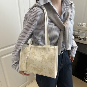 Sac fourre-tout beige minimaliste avec imprimés papillons dorés et pendentif à glands