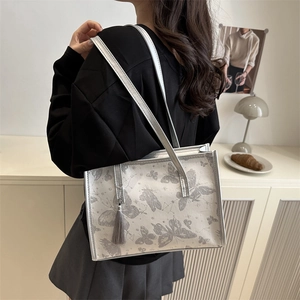 Sac fourre-tout argenté élégant avec imprimé papillon gris et pompon porté en intérieur