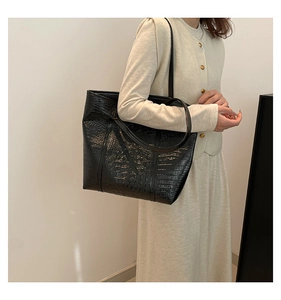 Close-up of black crocodile pattern leather tote bag with elegant glossy finish