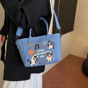 Denim tote bag with cartoon cat print and adjustable shoulder strap for casual wear