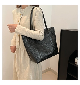 Detail of black crocodile pattern tote bag shown with a large capacity shoulder strap