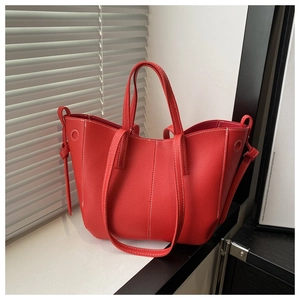 Detailed close-up of red lychee textured tote bag with white contrast stitching