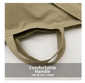 Close-up of durable reinforced stitching on the comfortable khaki canvas tote handles
