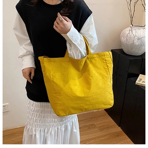 Detail of minimalist bright yellow canvas tote bag showcasing large capacity and soft texture