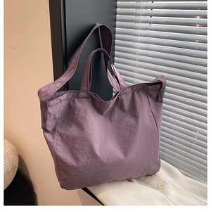 Detailed texture of purple canvas tote bag with subtle natural wrinkles and soft handles
