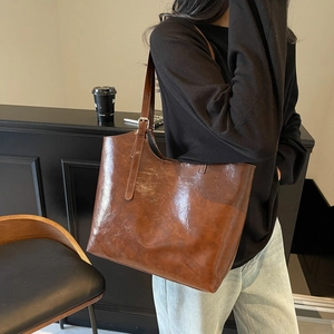Large dark brown leather tote bag with adjustable straps for stylish commuting use