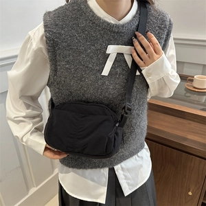 Minimalist black nylon crossbody bag with adjustable strap and waterproof fabric