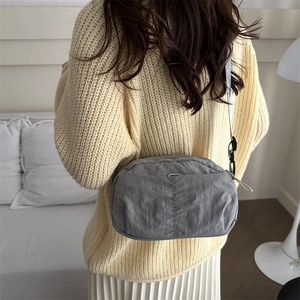 Minimalist grey nylon crossbody bag for daily commuting shown on a model