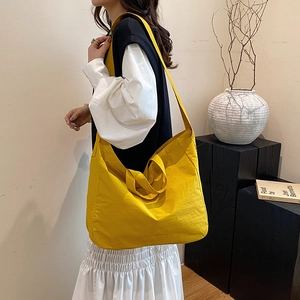 Minimalist bright yellow nylon tote bag for women showing large capacity and versatile straps