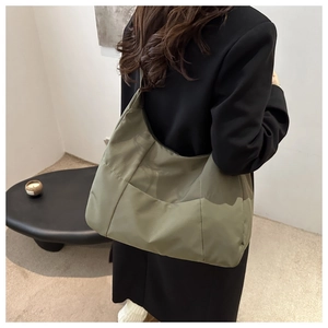 Detail of olive green nylon tote bag with layered stitching and spacious design