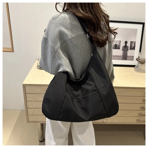 Close-up of black nylon hobo bag featuring wide shoulder strap and water-resistant fabric