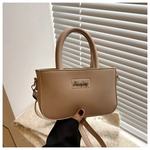 Close-up of a warm apricot crossbody bag with Shanfeng logo and elegant leather texture