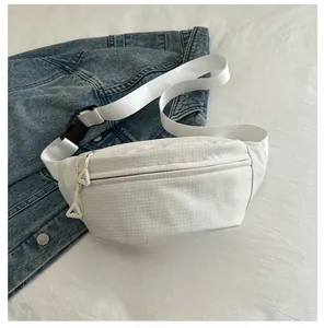 Detail of white checkered waist bag with adjustable strap and triangle zipper on denim
