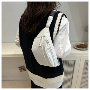 Detail of white waffle texture waist bag with adjustable straps on a model