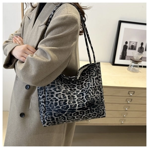 Large capacity leopard print canvas tote bag shown worn over the shoulder in an indoor setting