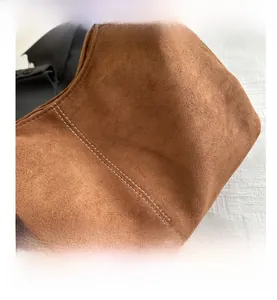 Close-up of brown suede tote bag featuring high-quality white double-stitching detail
