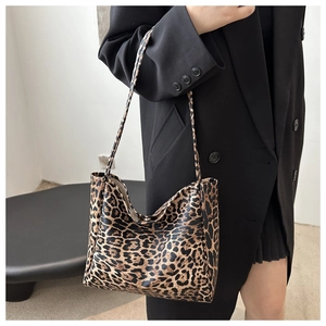 Detail of leopard print tote bag with metallic snap closure and textured finish