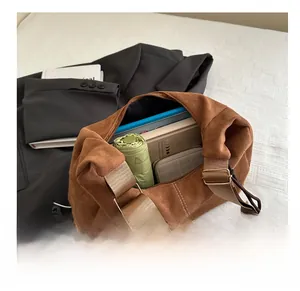 Brown suede tote bag interior showing large capacity with daily essentials and gold hardware