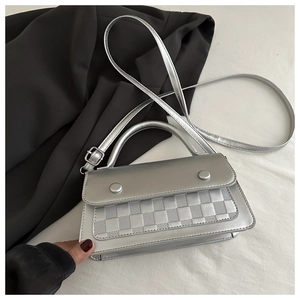 Detail of silver metallic crossbody bag with checkered texture and decorative buttons