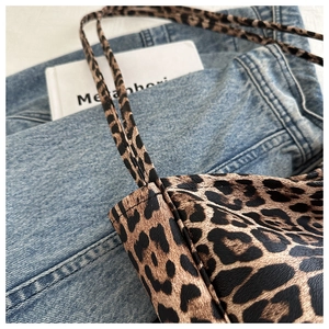 Close-up of leopard print tote bag texture and fine stitching on slim straps