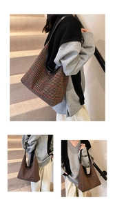 Close-up of retro plaid pattern fabric and black leather strap on a large tote bag