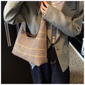 Detail of checkered hobo bag with yellow houndstooth pattern and brown trim for women