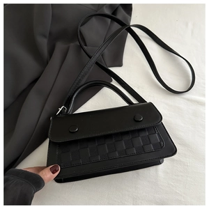 Close-up of black matte PU leather crossbody bag featuring checkerboard texture and buckles