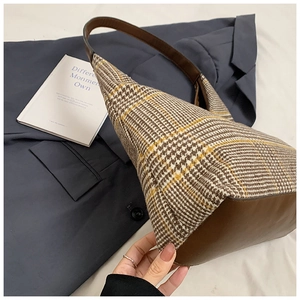 Close-up of brown houndstooth pattern texture and premium leather trim on shoulder bag