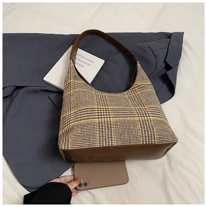 Close-up of vintage plaid hobo bag with brown leather trim and stylish check pattern